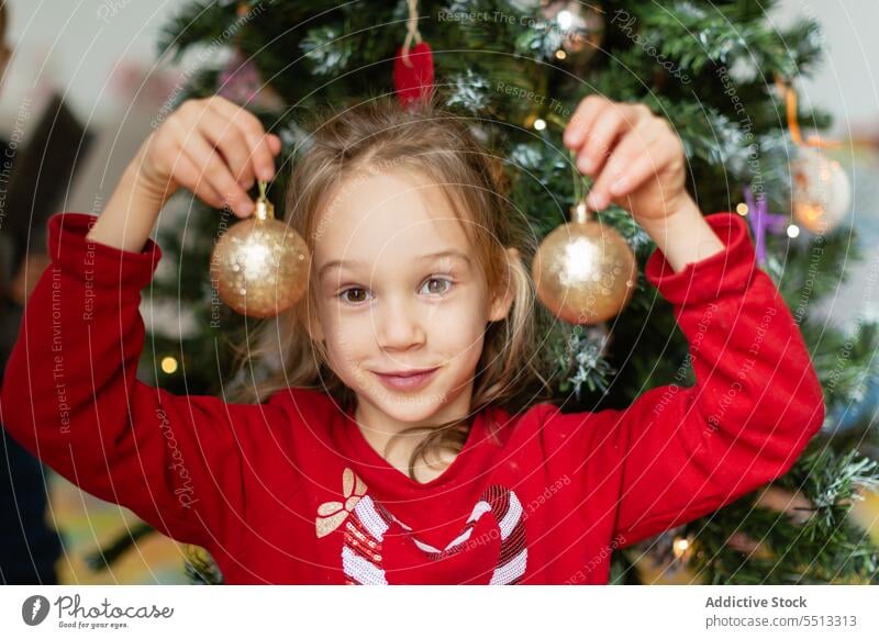 Mädchen mit Christbaumkugel am Weihnachtsbaum Russland Winter Kugel dekorieren Feiertag Weihnachten heimwärts vorbereiten Kind Vorabend festlich fröhlich