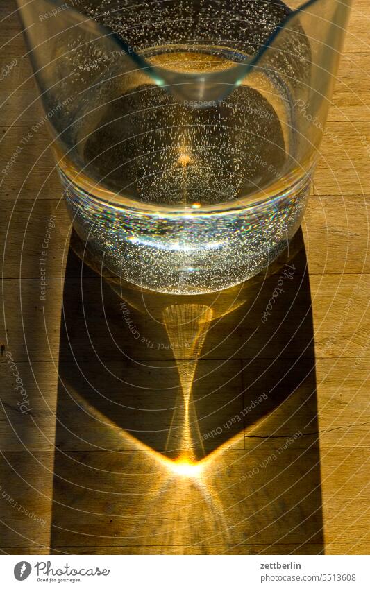 Ein Glas Wasser mit Sonne glas wasser trinken getränk durst sommer warm wärme hitze licht sonne lichtbrechung beugung optik bündelung lichtstrahlen tisch holz