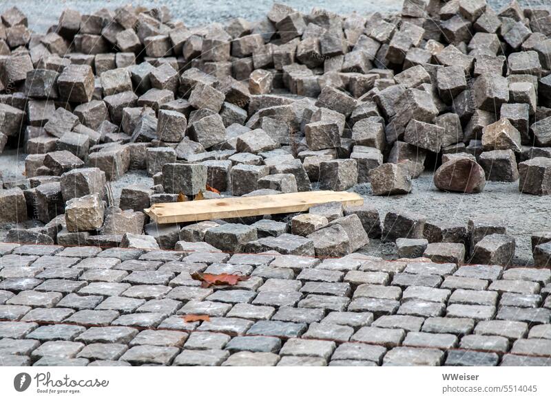 Ein Platz wird mit Pflastersteinen in ordentlichen Reihen ausgelegt Stein Boden Vorplatz Straßenarbeiten Baustelle bauen durcheinander Ordnung verlegen gehen