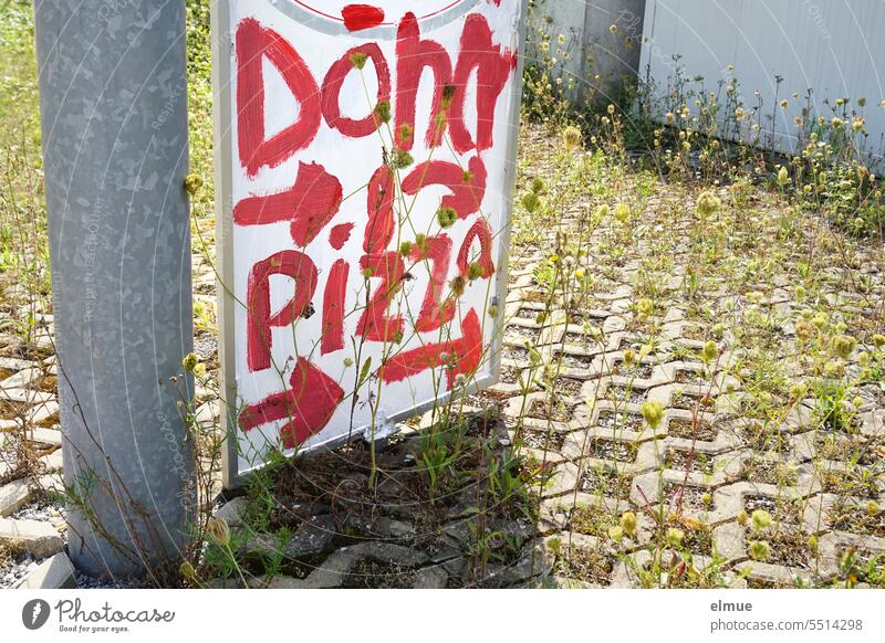handgeschriebenes Schild mit roter Schrift - Döner & Pizza - neben einer Metallstange und auf Rasenpflaster stehend Hunger Dönerbude Pizzabude Türkisches Essen