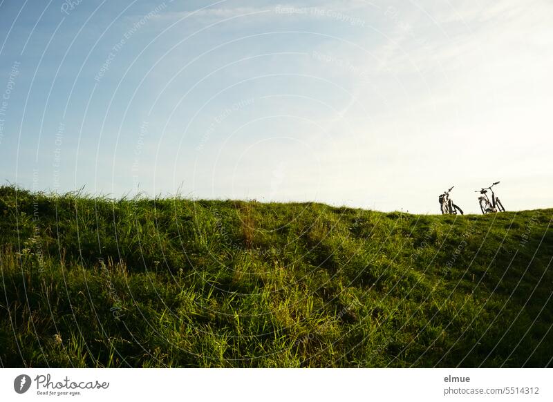 zwei Fahrräder stehen auf einem rasenbewachsenen Hügel Fahrrad Rad Ausflug Radtour paarweise Fahrradfahren Fahrradtour sportlich Bewegung Freizeit & Hobby