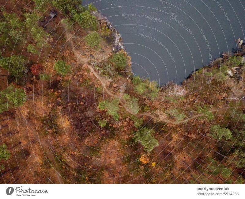 Malerische Luftaufnahme einer Landschaft mit smaragdgrünem See und Felsen inmitten eines herbstlichen Nadelwaldes im Granitsteinbruch von Korostyshiv, Bezirk Zhytomyr, nördliche Ukraine. Zhytomyr-Schlucht