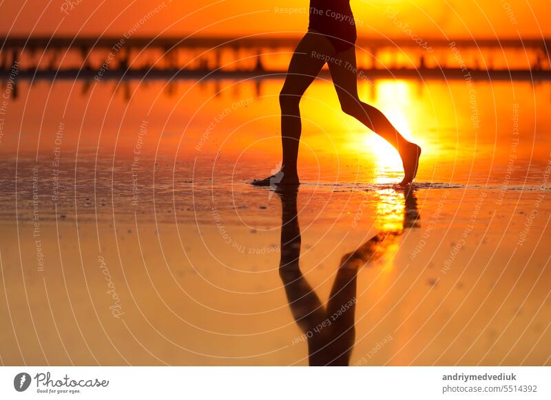 Aktive Sommer Reise tropischen Urlaub. Cropped Silhouette von Energie kleines Kind Mädchen hat Spaß läuft und spielt am Strand bei Sonnenuntergang. Jugend, Lebensstil und Glück Konzept. Kindertag