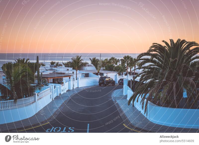eine Straße, Häuser und ein schöner Meerblick zum Sonnenuntergang in Lanzarote Insel Urlaub Urlaubsfoto Urlaubsort Urlaubsstimmung Sommer Sommerurlaub Abendrot