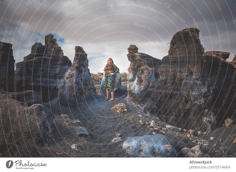 Frau mittleren Alters mit Kleid zwischen Felsen vor bewölktem Himmel Lanzarote posierend Natur Outdoor Aufstieg städter stadtmenschen Wolken Schönes Wetter