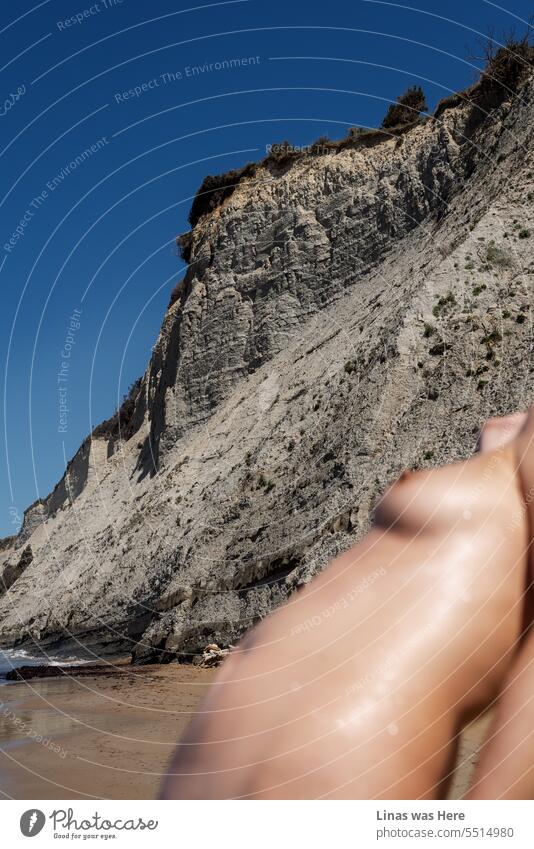 Es ist tolles Wetter draußen am Meer in Korfu, Griechenland. Und ein wunderschönes nacktes Mädchen lässt die Temperatur noch weiter steigen. Ihre sexy Kurven, die felsige Küste und der blaue Himmel passen gut zusammen. Ein erotisches Bild von altersloser Frauenschönheit.