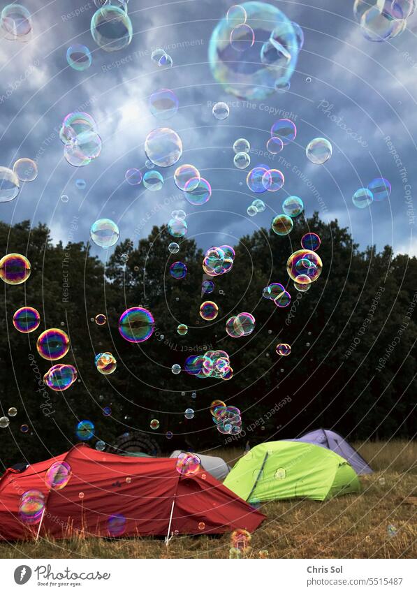 Seifenblasen fliegen über Zelte am Waldrand in dramatischen Himmel Zelten Festival Festivals Stimmung schweben Blasen stimmungsvoll Outdoor Party Veranstaltung