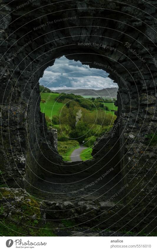 Dorfansicht durch ein altes Fenster Natur Wand Mauer Golfloch Menschenleer Weg grün Historie Republik Irland Burg oder Schloss alte Burg Eröffnung Blende Lücke