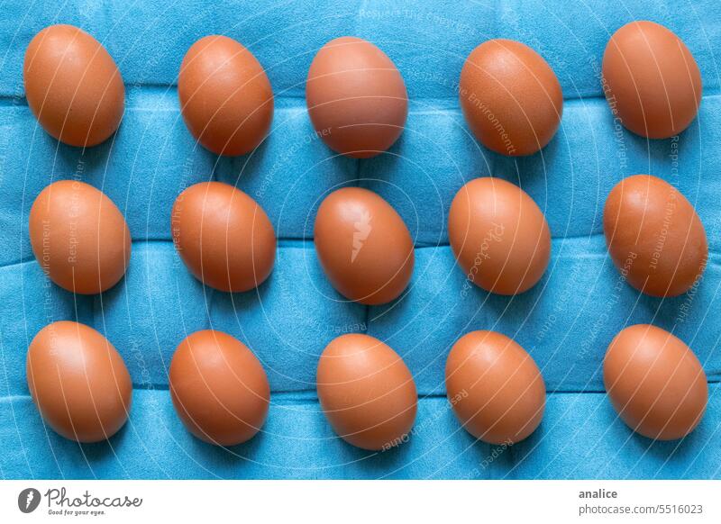 Reihe von ausgerichteten Eiern auf blauem Hintergrund braune Eier Blauer Hintergrund Ostern Lebensmittel bunte Eier Essen zubereiten Küche