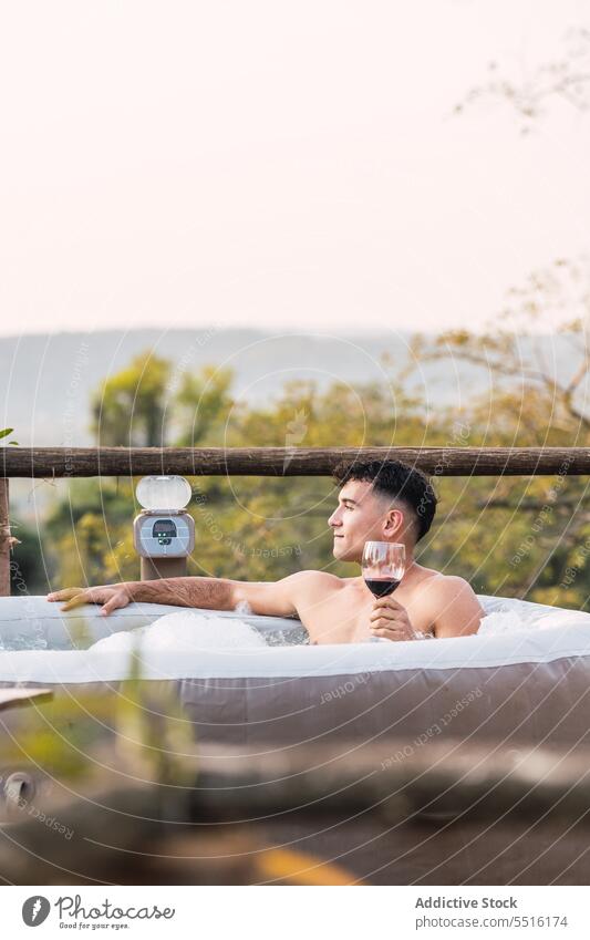 Entspannter Mann mit einem Glas Wein, der im Pool chillt Windstille Alkohol trinken sich[Akk] entspannen Terrasse Wasser aufblasbar Kälte männlich schäumen