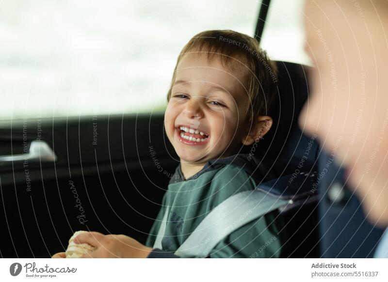 Lachende Kinder in Autositzen Junge PKW Sitz Gurt Fahrzeug Verkehr lässig Tageslicht Kindheit Automobil tagsüber Passagier Urlaub Sommer befestigen sorgenfrei