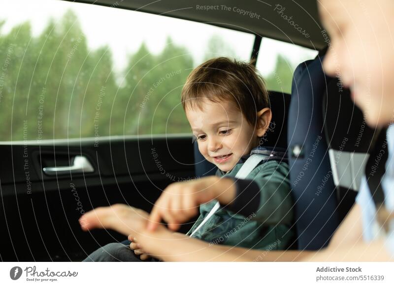 Lachende Kinder auf den Autositzen Junge PKW Sitz Gurt Fahrzeug Verkehr lässig Tageslicht Kindheit Automobil tagsüber Passagier Urlaub Sommer befestigen