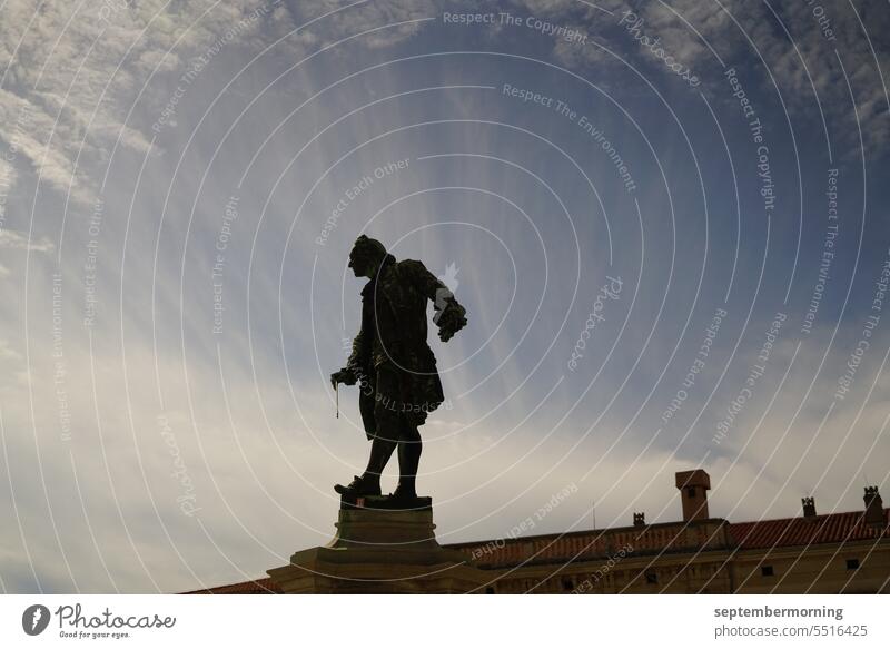 Statue eines Dirigenten vor Himmel Außenaufnahme Menschenleer Dirigentenstatue Silhouette blauer Himmel Wolken weiß schwarz
