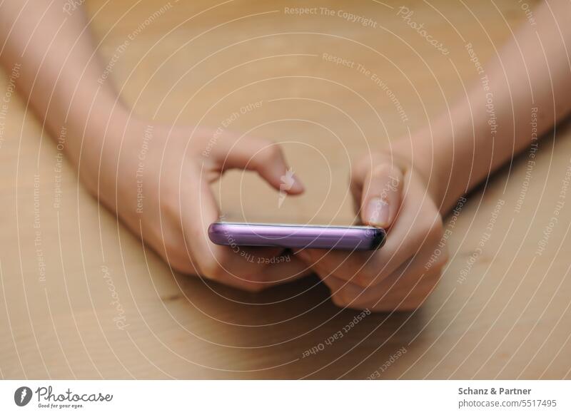 Kind oder Jugendliche hält mit ihren Händen ein Smartphone und tippt eine Nachricht digital whatsapp digitalisierung wischen tippen Internet online Tiktok