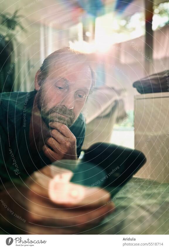 grenzwertig | Mann hängt (schon wieder) am Handy rum Smartphone Telefon Bett liegen zuhause Gegenlicht Technik & Technologie Mensch Gesicht Bart Regenbogen