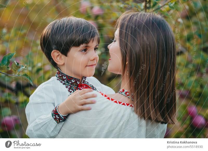 Familienporträt - 4 Jahre alter Junge umarmt Mutter im Apfelgarten. Zart. Mama Sohn Glück Umarmung Liebe Eltern Pflege Fröhlichkeit umarmend Mutterschaft