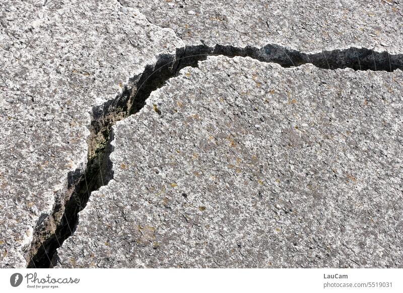 Erdspalte - Riss in der Landschaft Rissbildung Riss im Boden Stein Asphalt kaputt Straße durchtrennt Spalte Detailaufnahme grau Straßenbelag Teilung Beton