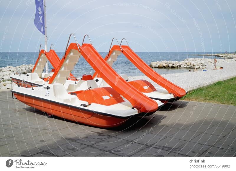 Tretboot mit Rutsche steht an Strandpromenade Ufer Promenade Boot Wasser Urlaub Ferien fahren Tourismus Wasserfahrzeug Bootsfahrt Ausflug