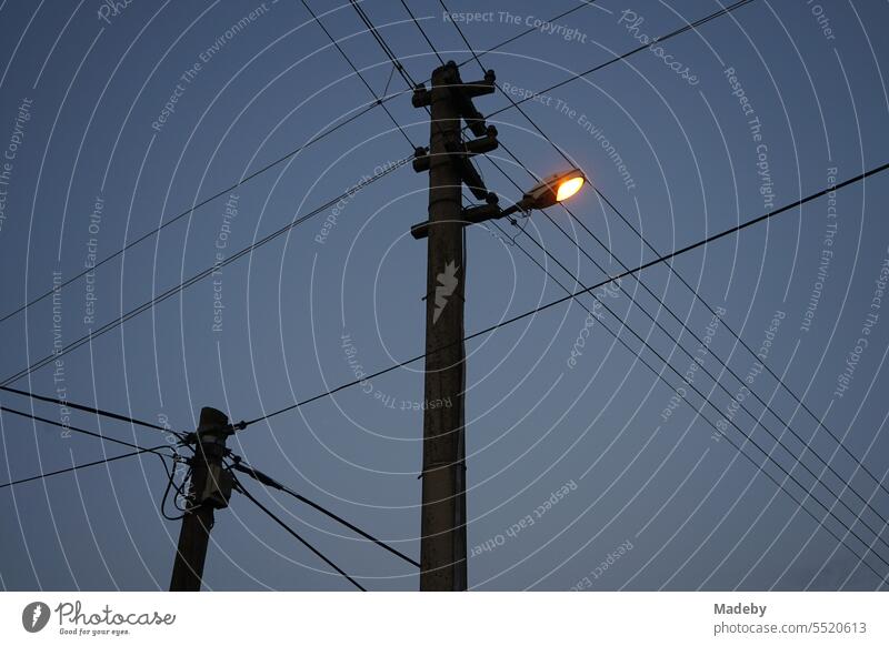 Stromleitungen mit Straßenbeleuchtung an einem Leitungsmast am Abend im Dorf Maksudiye bei Adapazari in der Provinz Sakarya in der Türkei maksudiye adapazari
