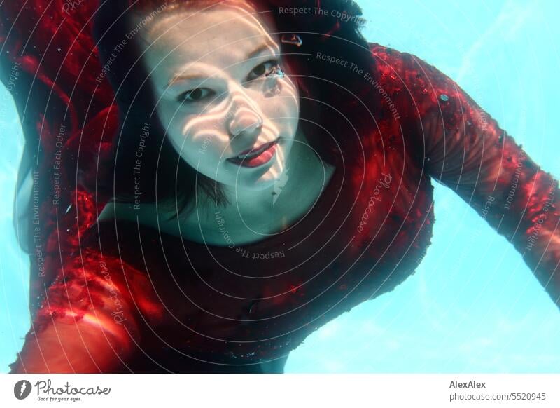 Denise - Unterwasser- Portrait einer jungen, schönen Frau mit rotem Ballkleid in einem Swimming- Pool Unterwasseraufnahme langhaarig portrait unter wasser
