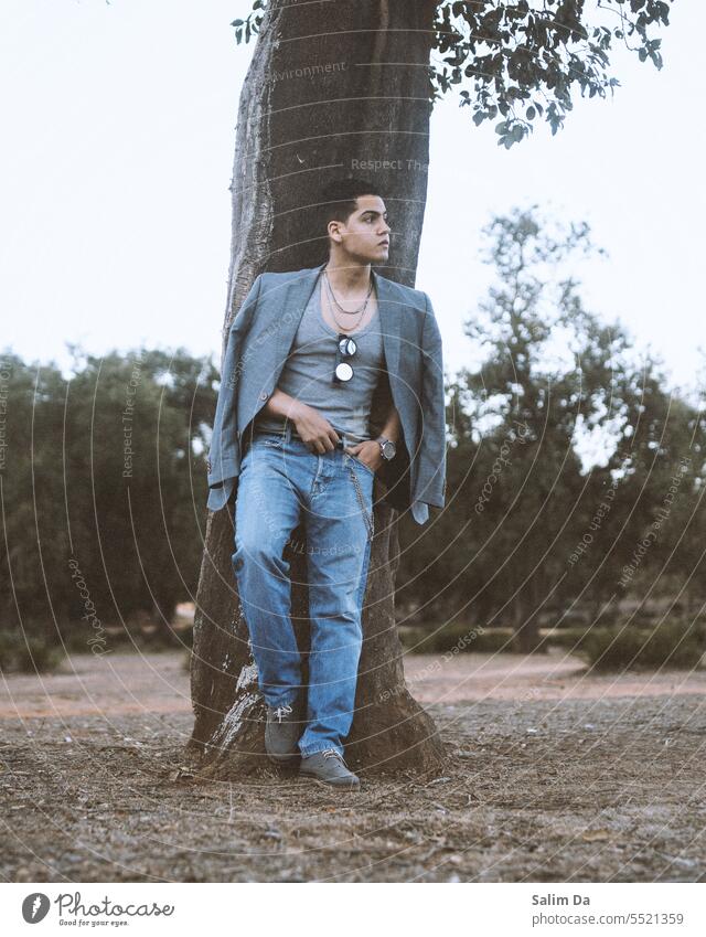Junger gutaussehender Mann in modischem, trendigem Outfit. Waldfotografie Jeanshose Jeansstoff Denim-Jeans jeansblau Weste Blazer grau Bekleidung Mode