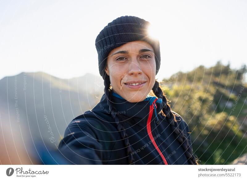 Eine junge Frau, Bergsteigerin, warm von der Kälte, nimmt ein Selfie, während sie die Landschaft und die Natur genießt Person Schönheit Glück Kaukasier Porträt