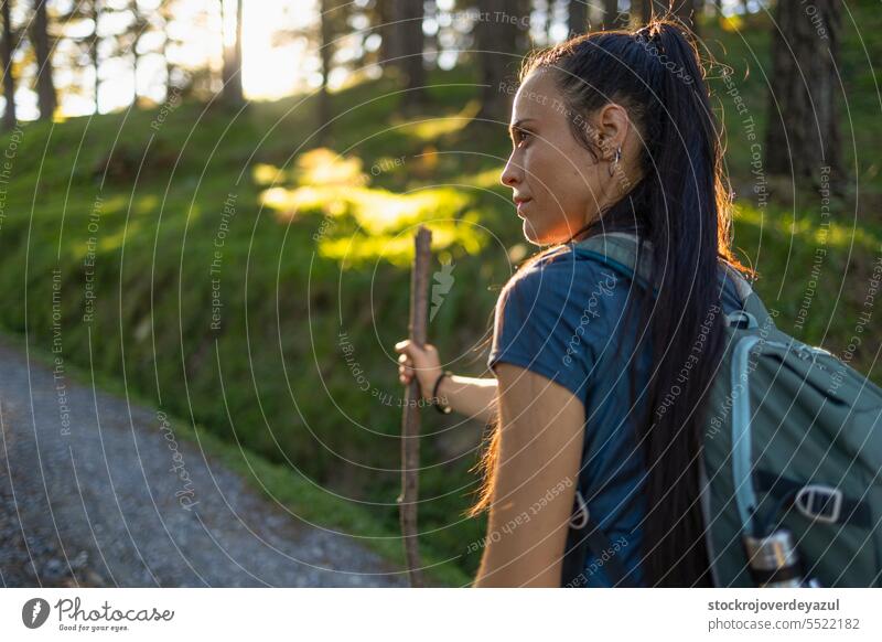 Eine junge Wanderin mit einem Holzstock als Wanderstock genießt die Natur bei einem Spaziergang Person Frau Porträt Schönheit Erwachsener Lifestyle hübsch Wald