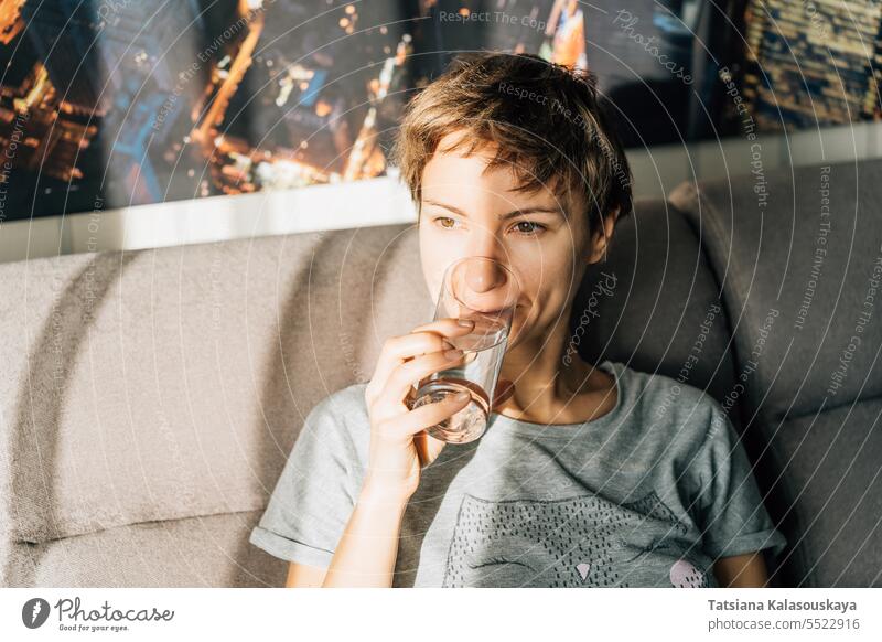 Porträt einer kurzhaarigen jungen Frau, die Wasser aus einem Glas trinkt häusliches Leben Menschen trinken Person Kaukasier 30-40 Jahre Gerichte Wasserglas