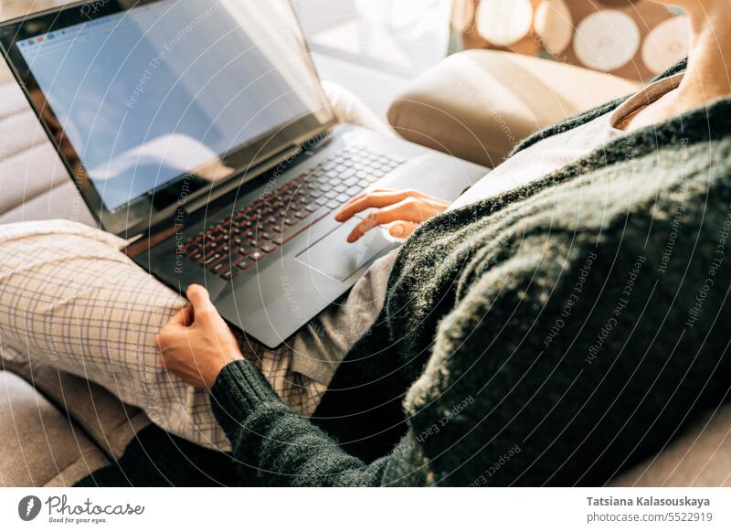 Eine Frau benutzt ein Laptop-Touchpad, während sie zu Hause sitzt online Internet Lebensstile Fernarbeit WiFi Computer Drahtlose Technologie Menschen Job