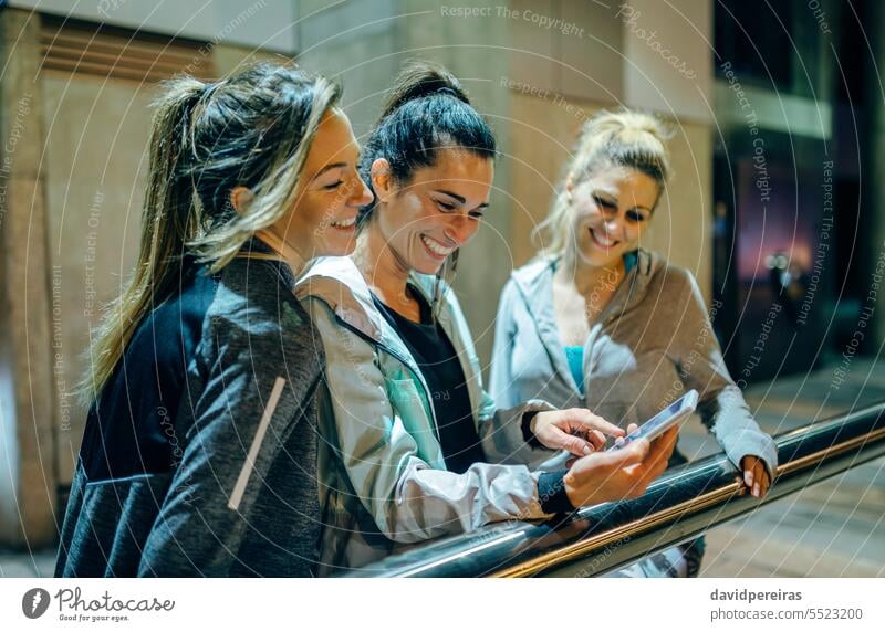 Glückliche Freundinnen lachen beim Betrachten eines Streaming-Videos einer Social-Media-App auf einem Mobiltelefon Porträt Frauen Lachen habend Spaß Blick