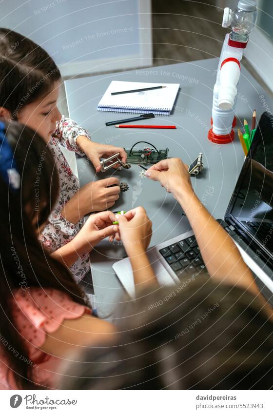 Lehrerin hilft Schülerinnen beim Zusammenbau von Maschinenteilen in einem Robotikkurs Frau unkenntlich zu erklären. Hilfe Kinder versammeln elektronisch