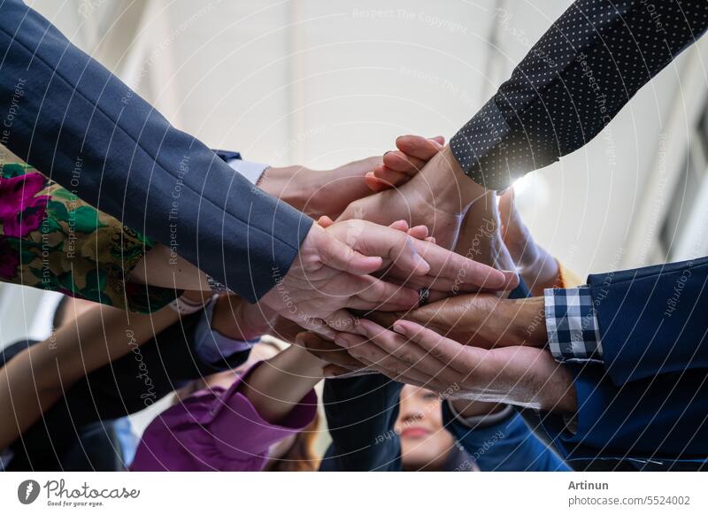 Team, Teamarbeit und Einheitsbegriff. Unterschiedliche Teams reichen sich die Hände. Eine Gruppe von Geschäftsleuten. Gemeinsam als Team arbeiten. Partnerschaft und Zusammengehörigkeit schaffen ein starkes Gefühl der Gemeinschaft.