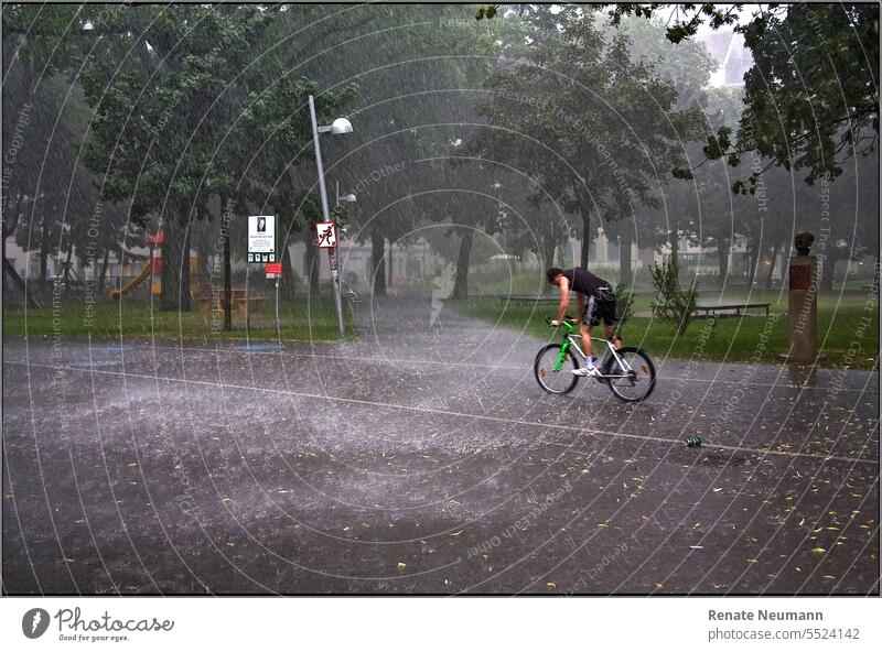 Radfahrer im strömenden Regen Street Fahrrad Sport Bike Regenguss Wetter Wetterumschwung Schlechtwetter Park Fahrradfahren im Freien Freizeit Biker Radfahren