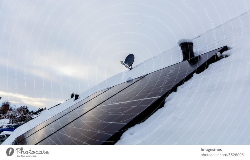 Sonnenkollektoren auf dem Dach mit Schnee im Winter Winter. Schneeräumung Photovoltaikanlage Solarzellen Paneele Strom Energieeffizienz Kälte Aktivität