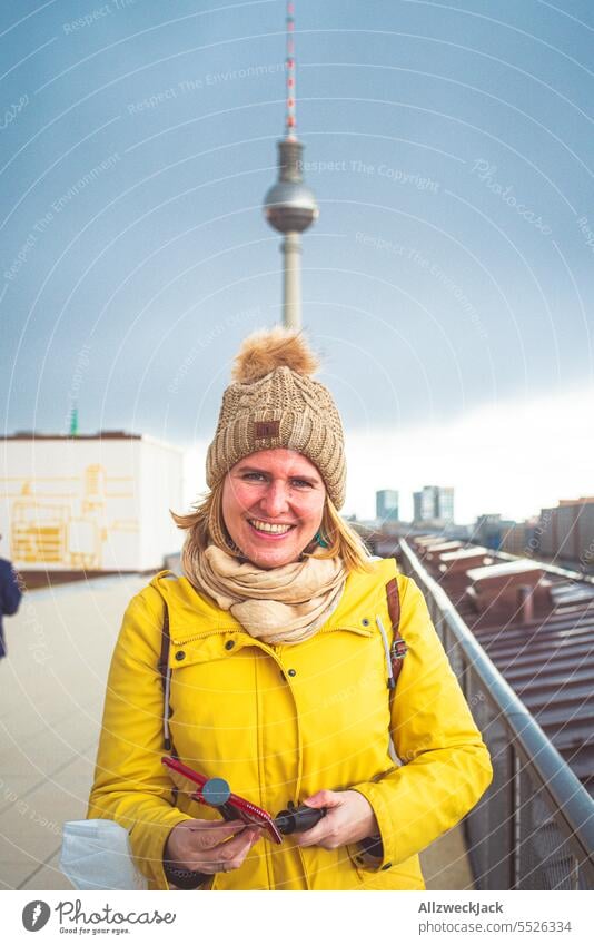 Portrait einer jungen blonden Frau mit herbstlicher Kleidung und Pudelmütze vor dem Fernsehturm Berlin Berlin-Mitte Berliner Fernsehturm park inn Hotel Skyline