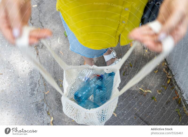 Gesichtslose Frau hält Tasche mit Plastikflaschen Kunststoff Flasche Wasser wiederverwerten führen Müll Umwelt verseucht Abfall Problematik Haufen Ökologie