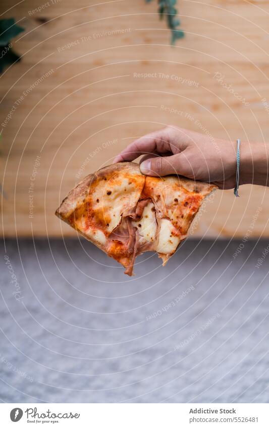 Unbekannte Person hält bei Tageslicht ein leckeres Pizzastück in der Hand gebacken Tomate Lebensmittel Spielfigur geschmackvoll Mahlzeit frisch appetitlich