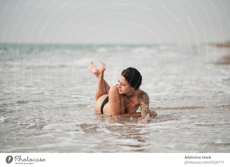 Sinnliche Frau im Bikini am Meeresstrand liegend Gesäß oben ohne MEER Strand genießen schäumen Meeresufer Glück sich[Akk] entspannen Urlaub Sommer jung
