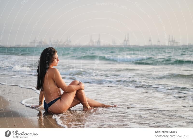 Oben-ohne-Frau entspannt sich im Meerwasser am Ufer oben ohne sinnlich Strand Meeresufer Wasser schäumen Sommer Urlaub MEER nasses Haar Sand Küste