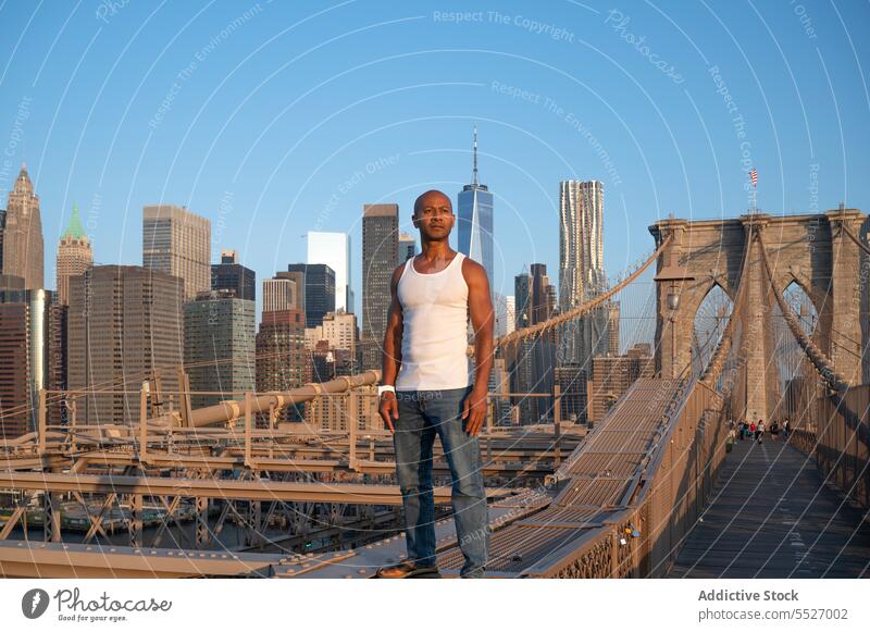 Mann steht auf einer Hängebrücke in Brooklyn Infrastruktur nachdenklich ernst selbstbewusst Afroamerikaner Brooklyn Bridge Architektur Brücke schwarz ethnisch