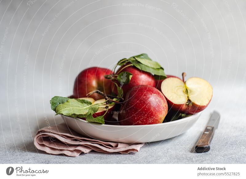 Frische Äpfel im Teller auf grauer Oberfläche Apfel Messer Frucht reif Stoff Vitamin frisch Haufen organisch natürlich Lebensmittel Gesundheit lecker Ernährung