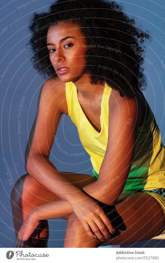 Verführerische ethnische Frau in Aktivkleidung sinnlich Verlockung Model Kinn berühren Afro-Look Studioaufnahme Stil feminin Vorschein elegant Afroamerikaner