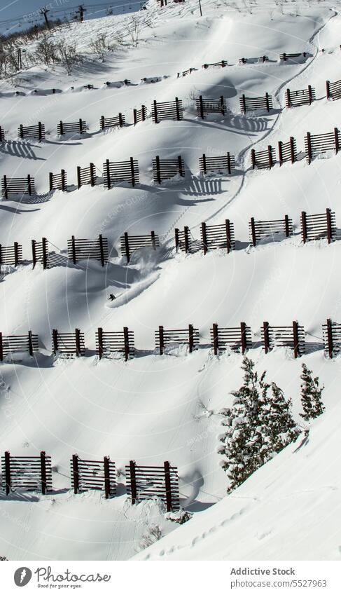 Verschneite Piste mit Holzzäunen im Wintersportgebiet Ski Berghang Schnee Sport Aktivität Sliden Hobby aktiv Berge u. Gebirge kalt Hügel extrem Lifestyle