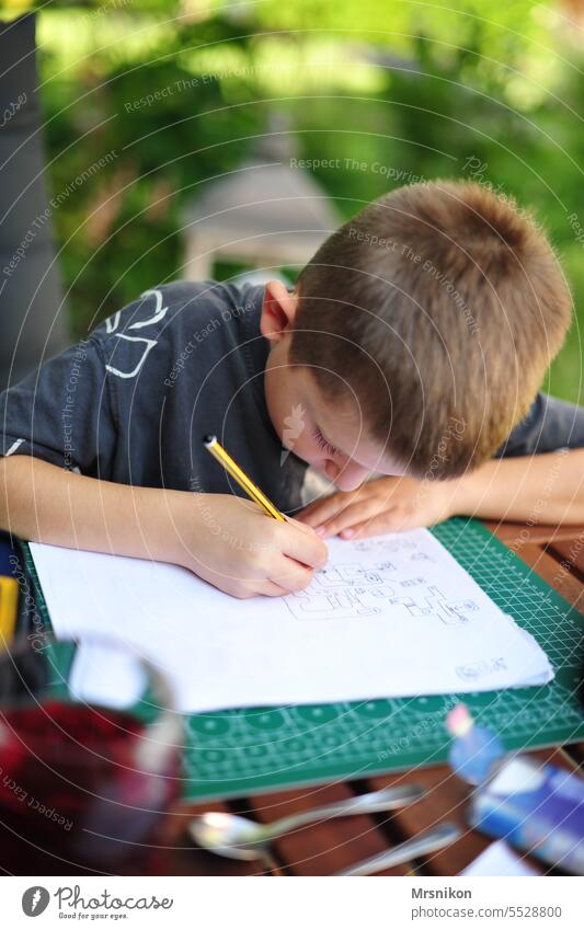 konzentriert Konzentration konzentrieren malen Kind Kindheit Junge Stift Garten draußen stille Stillleben allein Hobbies hobby Malerei u. Zeichnungen