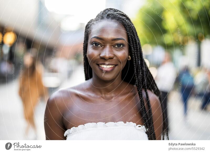 Porträt einer schönen jungen Frau, die in der Stadt lächelt Erwachsener attraktiv schwarz Selbstvertrauen selbstbewusst cool Mädchen Frisur Freizeit Lifestyle