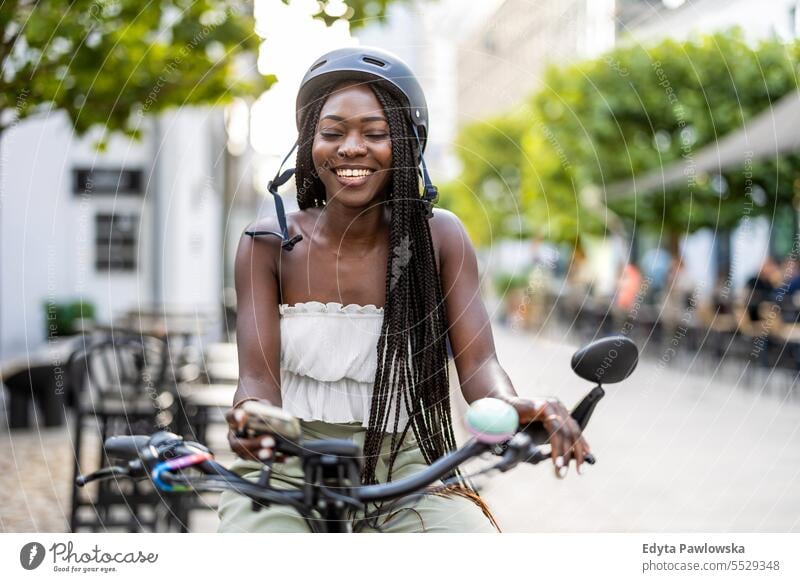 Porträt einer jungen Frau mit ihrem Fahrrad in der Stadt Erwachsener attraktiv schön schwarz Selbstvertrauen selbstbewusst cool Mädchen Frisur Freizeit