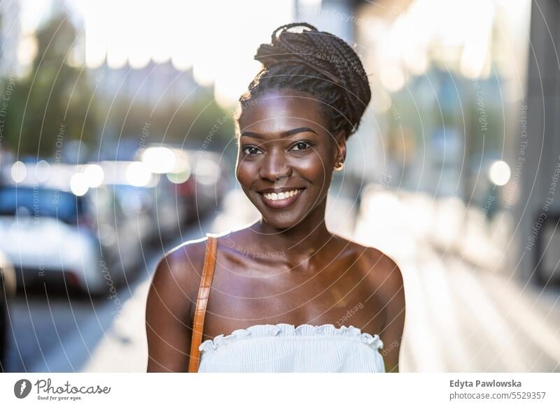 Porträt einer schönen jungen Frau, die in der Stadt lächelt Erwachsener attraktiv schwarz Selbstvertrauen selbstbewusst cool Mädchen Frisur Freizeit Lifestyle