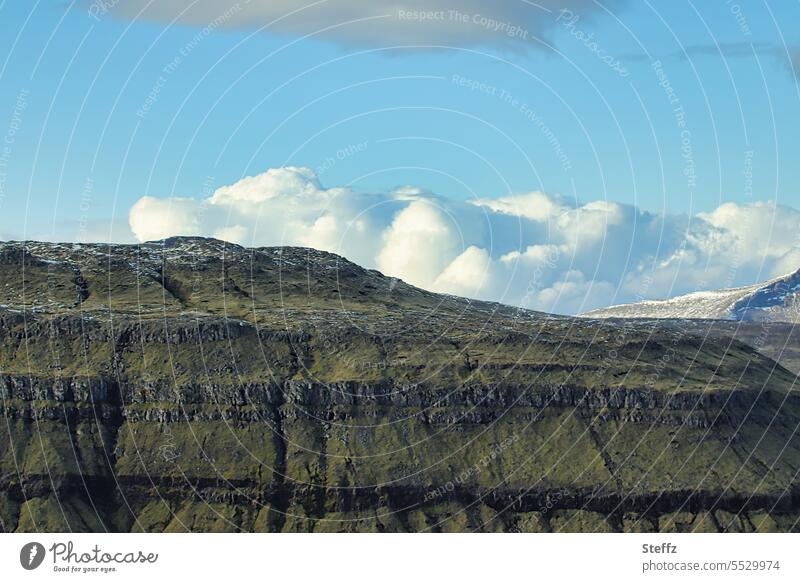 Färöer Inseln mit Wolken und dem blauen Himmel Färöerinseln Färöer-Inseln Schafsinseln friedlich Felsen abgeschieden Felsenwand Felshügel Felsufer Hügel