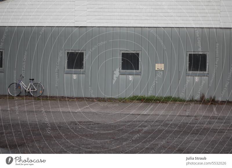 Weites Land | Fahrrad auf dem Parkplatz der Kometen vereinsheim stehen angelehnt Fenster vergitterte Fenster Alu Fassade Außenaufnahme Gebäude Haus Einsam