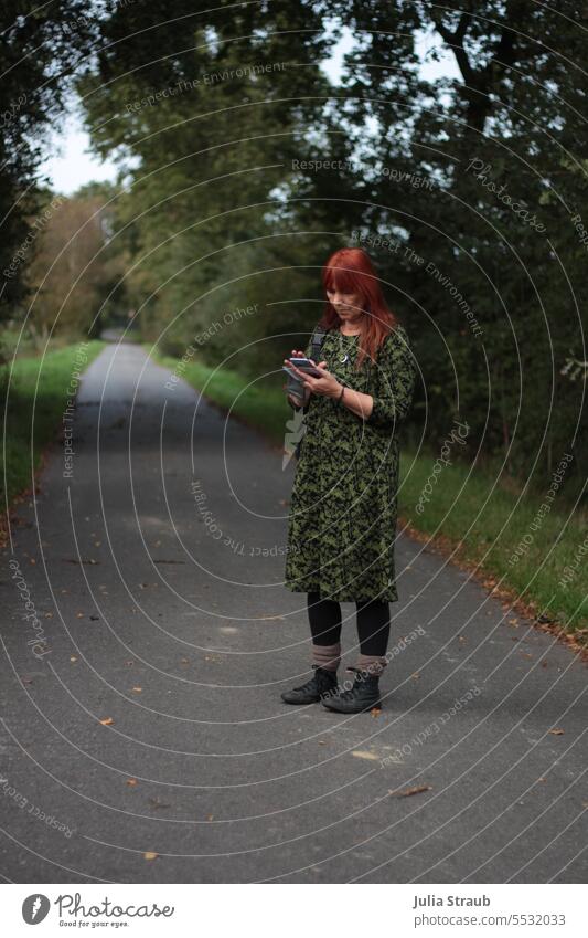 Weites Land | Da müsst ihr hin Weg Straße grün Bäume Handy mobiltelefon Navigation Orientierung Tippen organisieren stehen Frau rote Haare Kleid Turnschuh